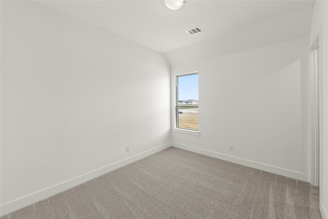 carpeted empty room with lofted ceiling