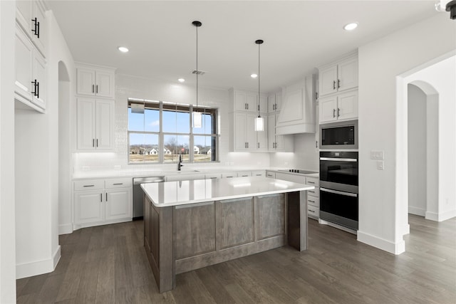 kitchen featuring a center island, dark hardwood / wood-style flooring, white cabinets, black appliances, and custom range hood