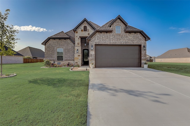 french country home featuring a front yard and a garage