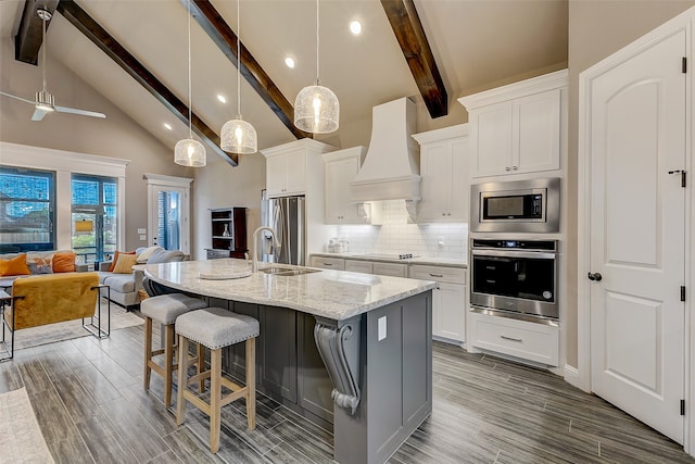 kitchen featuring white cabinets, stainless steel appliances, and custom range hood