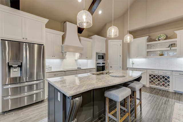 kitchen with white cabinets, stainless steel appliances, decorative light fixtures, and custom exhaust hood