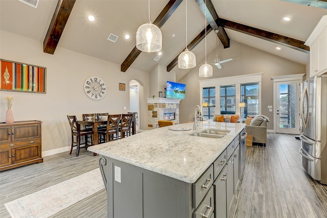 kitchen featuring gray cabinetry, sink, hanging light fixtures, appliances with stainless steel finishes, and light hardwood / wood-style floors