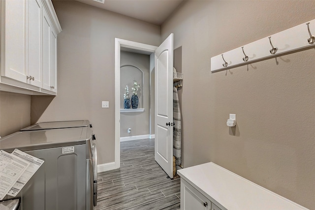 laundry room with washer and clothes dryer, cabinets, and light hardwood / wood-style floors