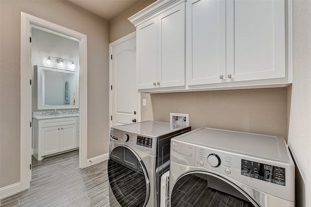 laundry area with washer and clothes dryer, cabinets, and sink