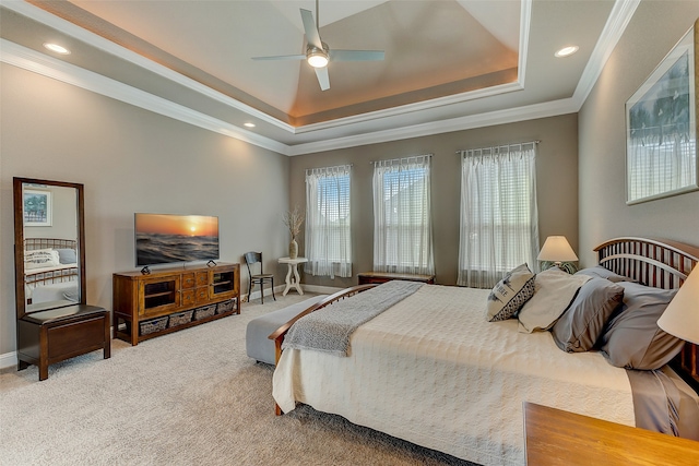 bedroom with ceiling fan, carpet floors, crown molding, and a tray ceiling