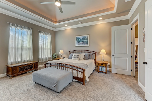 carpeted bedroom featuring a raised ceiling, ceiling fan, and ornamental molding