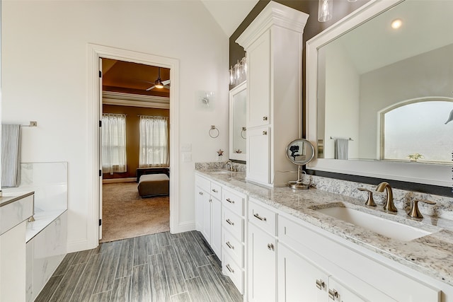 bathroom with vanity, wood-type flooring, and vaulted ceiling