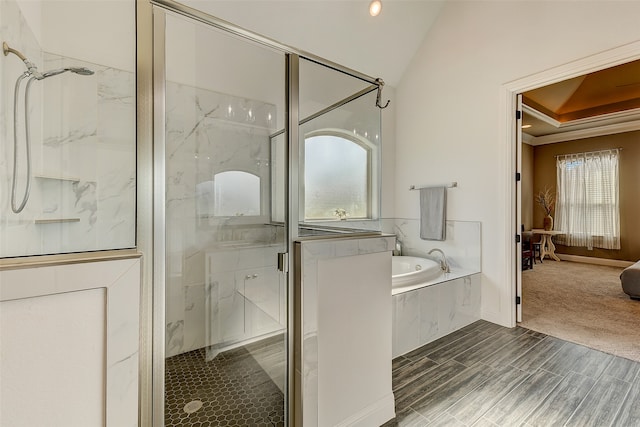 bathroom with plus walk in shower, hardwood / wood-style floors, vaulted ceiling, and ornamental molding