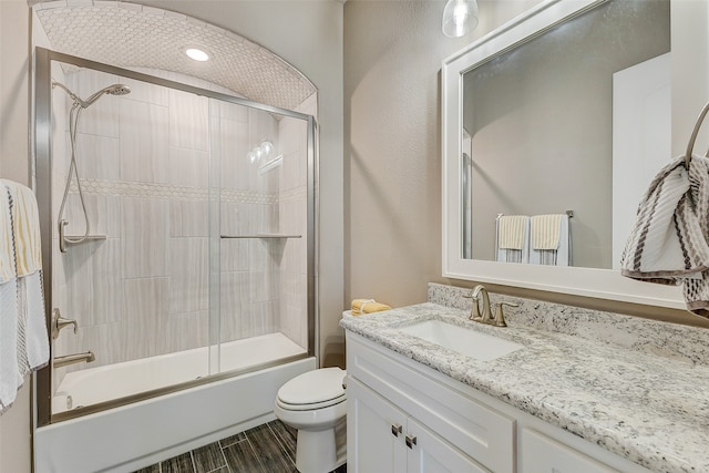 full bathroom featuring vanity, toilet, and bath / shower combo with glass door