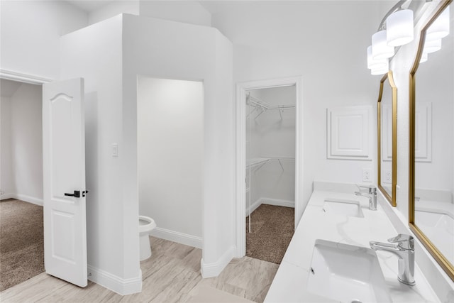 bathroom with toilet, vanity, and hardwood / wood-style flooring