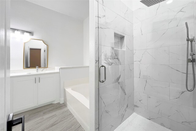 bathroom with vanity, hardwood / wood-style floors, and plus walk in shower