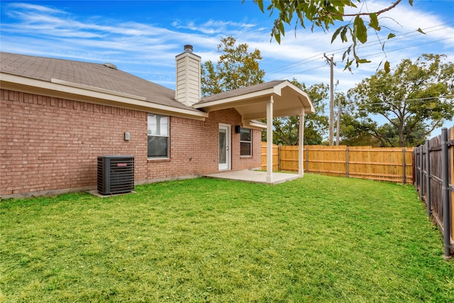 rear view of property with a patio, central AC, and a lawn