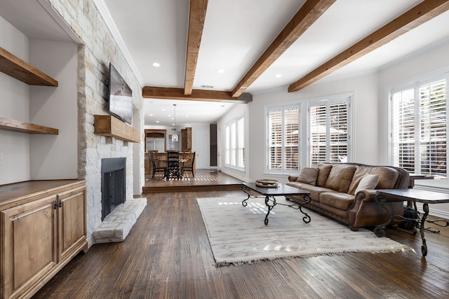 living room featuring a fireplace, dark hardwood / wood-style flooring, beamed ceiling, and a healthy amount of sunlight