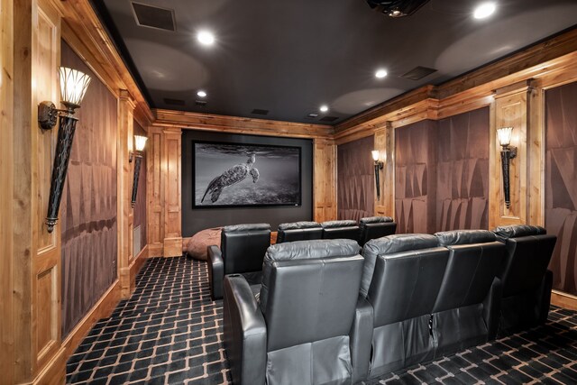 carpeted cinema room featuring wood walls