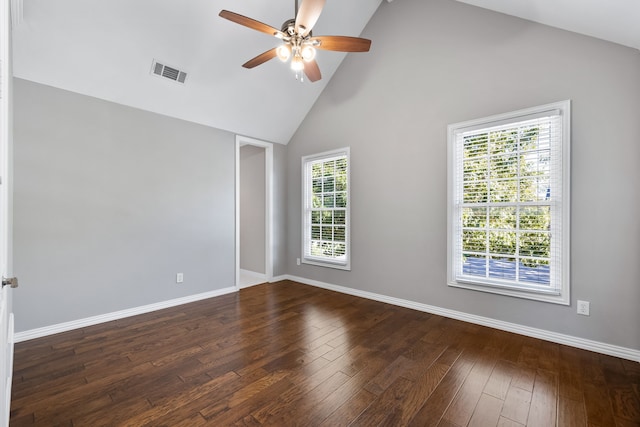 empty room with dark hardwood / wood-style floors, high vaulted ceiling, a wealth of natural light, and ceiling fan