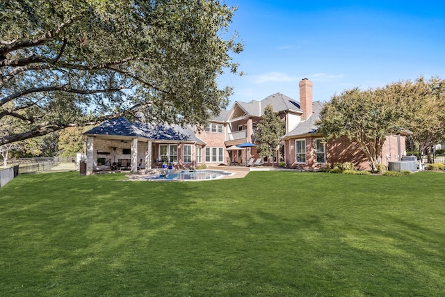 back of house with a patio, ceiling fan, and a lawn