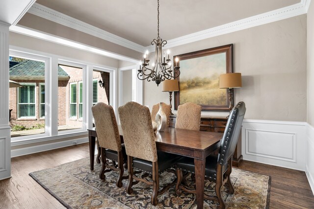 dining area with dark hardwood / wood-style flooring, ornamental molding, and a chandelier