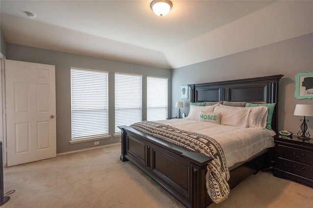 carpeted bedroom with lofted ceiling