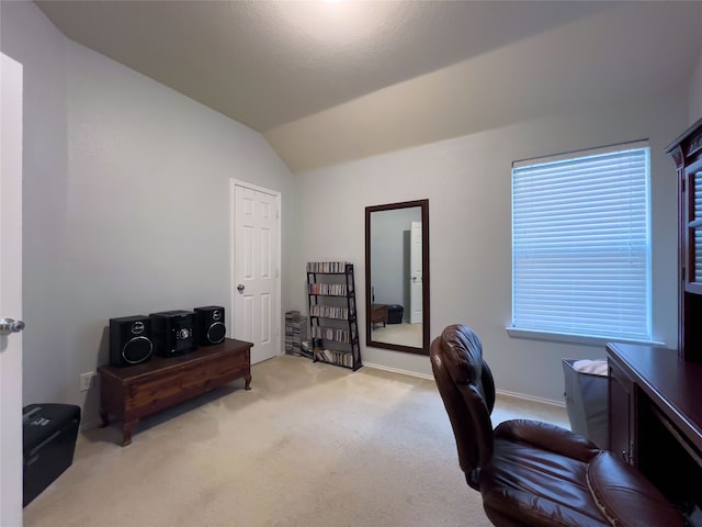 carpeted home office featuring lofted ceiling