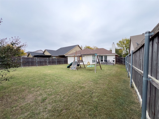 back of property with a playground and a yard