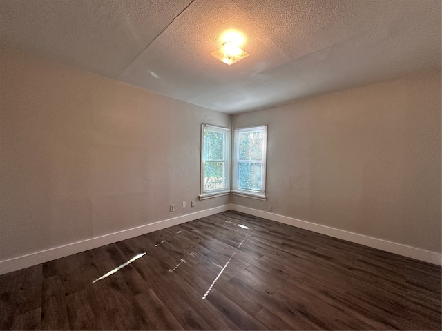 unfurnished room with a textured ceiling and dark hardwood / wood-style floors