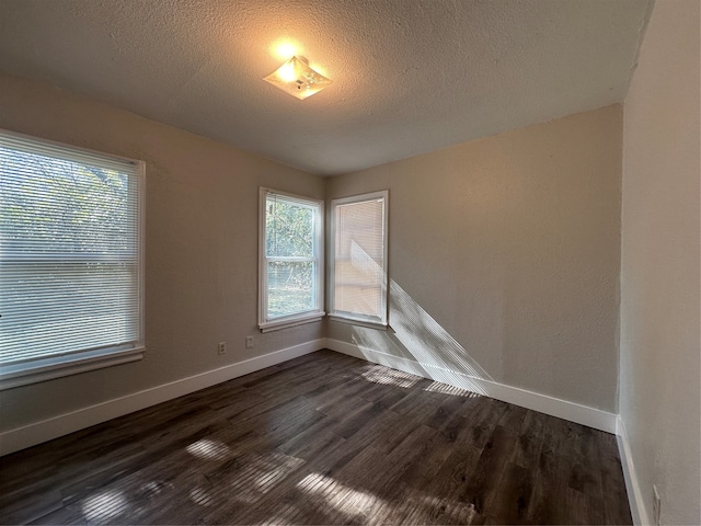 empty room featuring dark hardwood / wood-style flooring and a textured ceiling