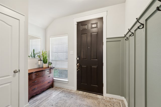 foyer with light hardwood / wood-style flooring and vaulted ceiling