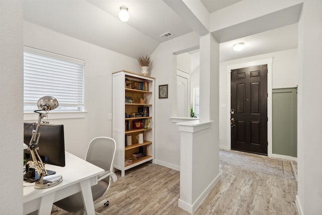 office area with light hardwood / wood-style floors and vaulted ceiling