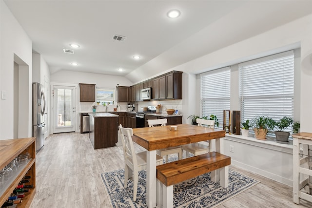 dining space with lofted ceiling and light hardwood / wood-style flooring