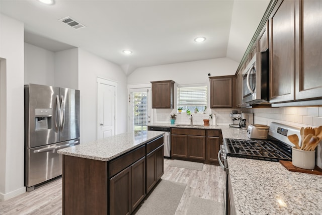 kitchen featuring sink, light wood-type flooring, stainless steel appliances, and tasteful backsplash