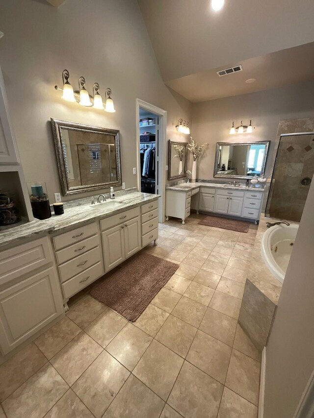 bathroom featuring tile patterned floors, vanity, lofted ceiling, and independent shower and bath