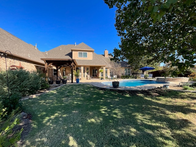 rear view of house featuring a patio and a lawn