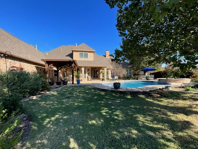 rear view of house featuring a patio and a lawn