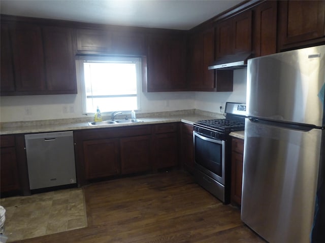 kitchen featuring stainless steel appliances, sink, dark wood-type flooring, and dark brown cabinetry