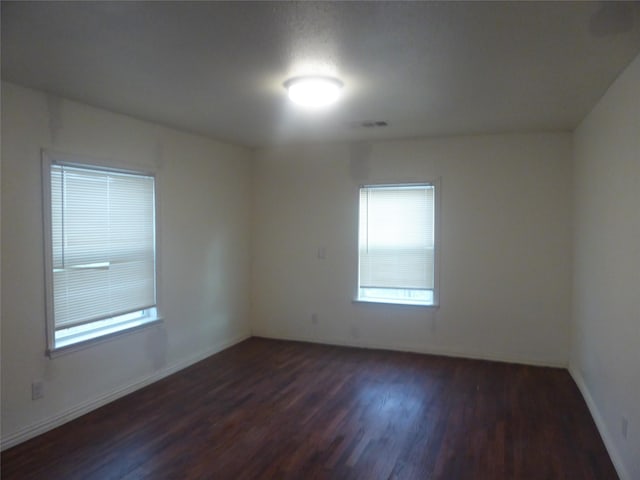 spare room with dark hardwood / wood-style floors