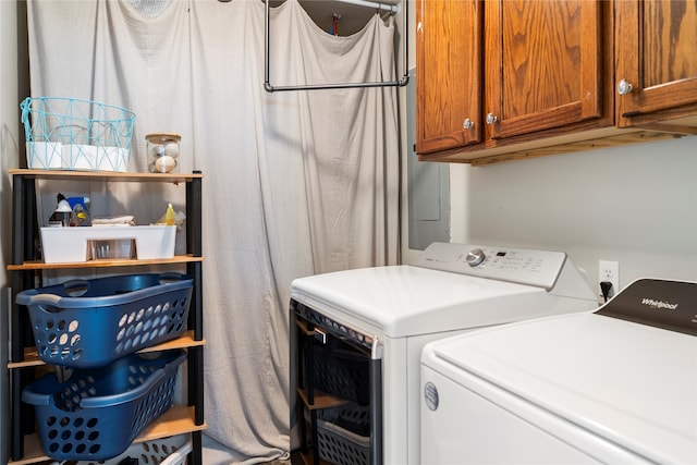 laundry room featuring washing machine and clothes dryer and cabinets