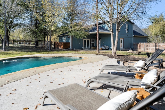 view of swimming pool with french doors and a patio