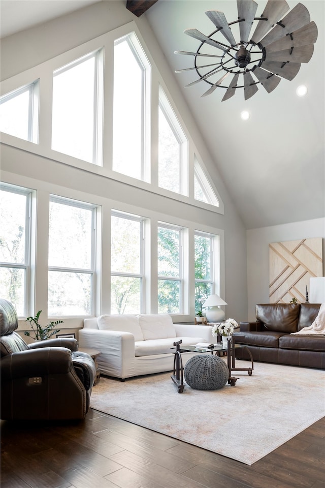 living room with high vaulted ceiling, dark wood-type flooring, and a wealth of natural light