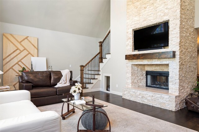 living room featuring a stone fireplace and hardwood / wood-style floors