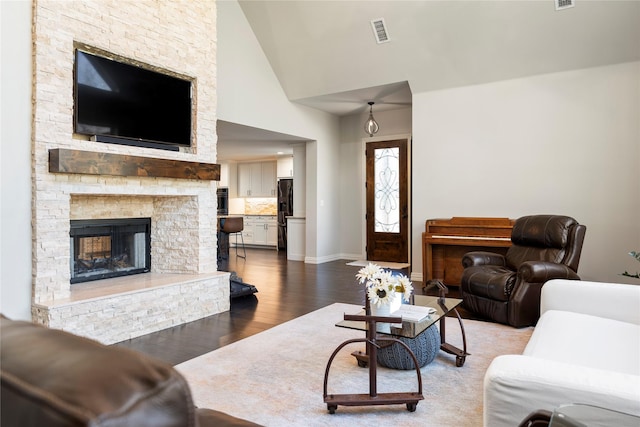 living room featuring hardwood / wood-style flooring, a fireplace, and a high ceiling