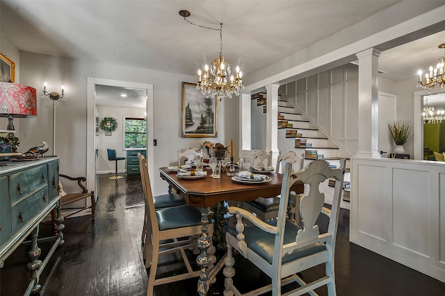 dining space with decorative columns, dark hardwood / wood-style flooring, and an inviting chandelier