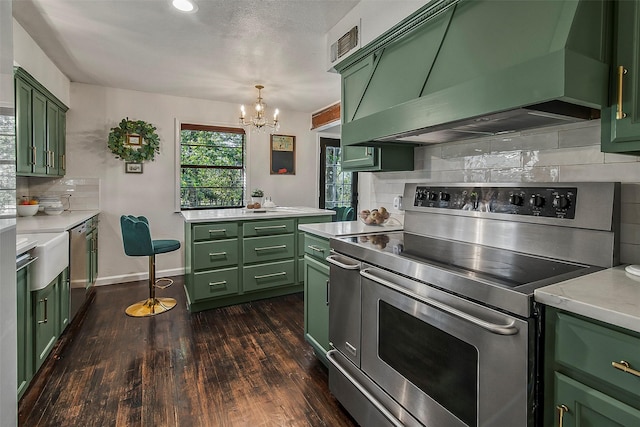 kitchen featuring ventilation hood, dark hardwood / wood-style floors, green cabinets, stainless steel appliances, and backsplash