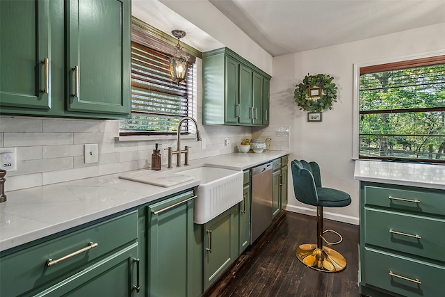 kitchen with dark wood-type flooring, sink, stainless steel dishwasher, green cabinets, and backsplash