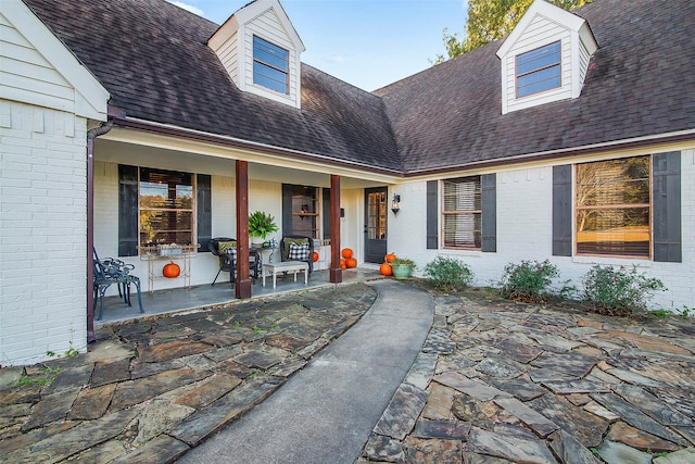 view of exterior entry featuring covered porch