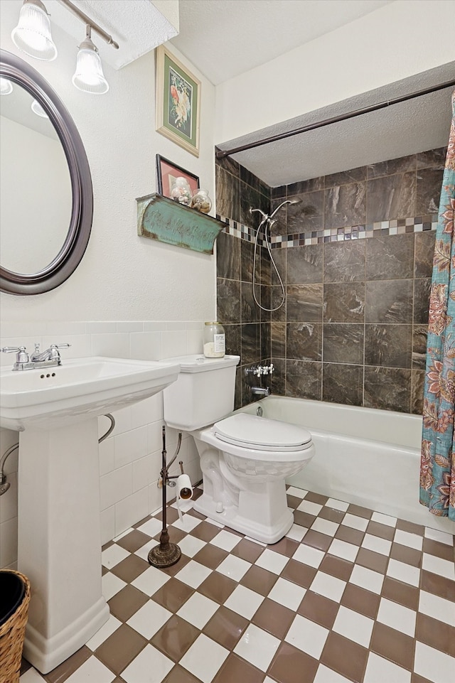 full bathroom featuring sink, a textured ceiling, toilet, and shower / bath combo