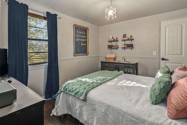 bedroom with dark hardwood / wood-style floors and a notable chandelier