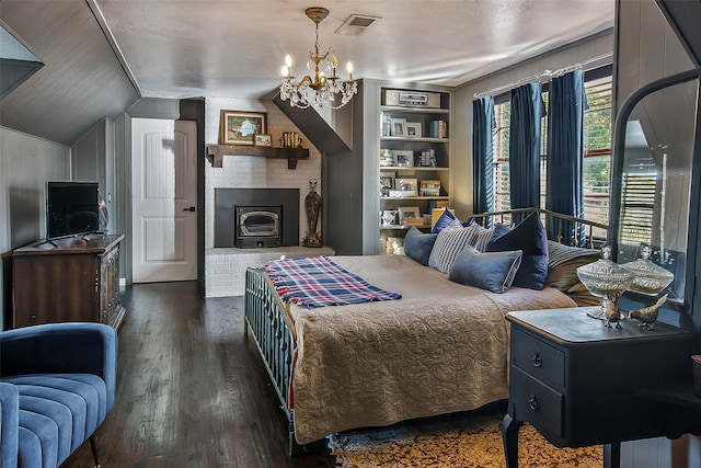 bedroom with dark hardwood / wood-style flooring, a brick fireplace, vaulted ceiling, and a chandelier