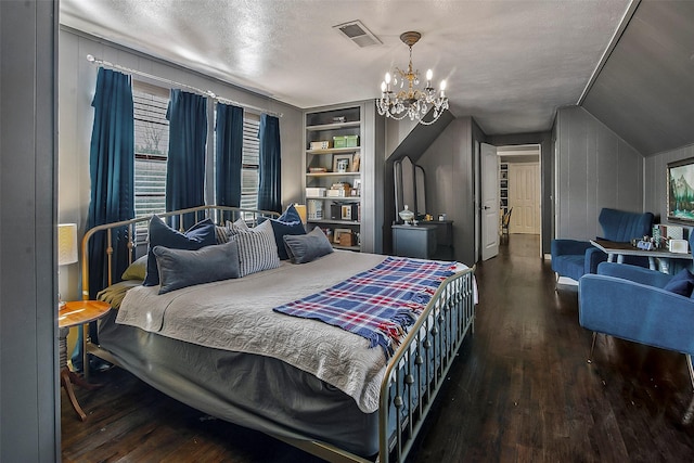 bedroom featuring lofted ceiling, hardwood / wood-style floors, a notable chandelier, and a textured ceiling