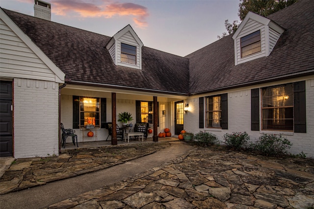 cape cod home with a porch and a garage