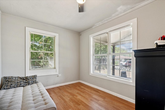 sitting room with crown molding, a healthy amount of sunlight, and wood-type flooring